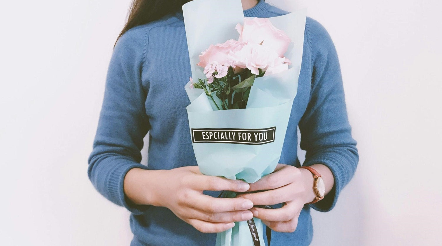 Female employee holding bouquet of pink flowers